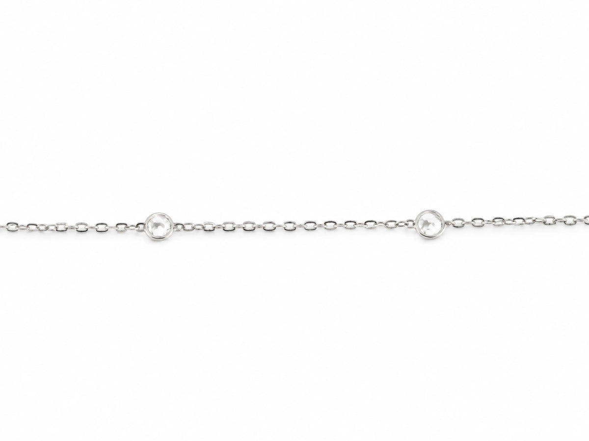 Close view of the cable chain and the two round diamonds set in polished bezels, one on each side