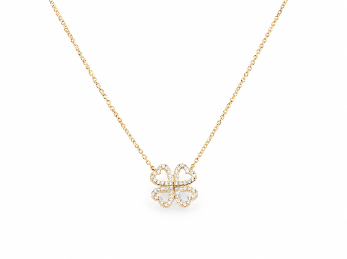 14K yellow gold clover necklace laid out with the four leaf pendant at the centre, each leaf an open heart outline lined with small lab grown diamonds