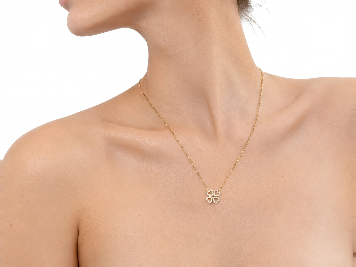 The clover necklace worn close at the base of the neck, the jaw at the top of the frame
