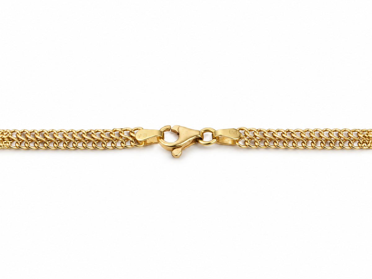 Macro detail of the lobster clasp and end caps on the gold chain necklace