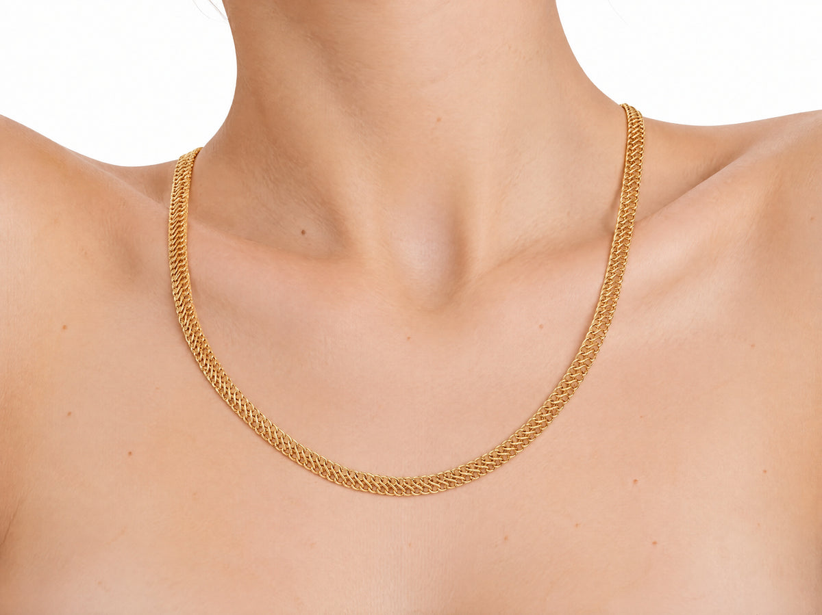 Woven gold chain necklace worn on the neck, three-quarter view