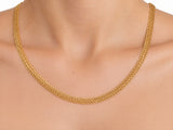Woven gold chain necklace worn on the neck, front view