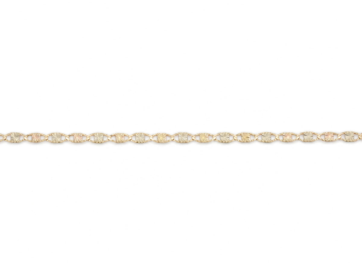 14K gold piastrine chain laid straight, plate links with alternating starburst centres and both ends visible