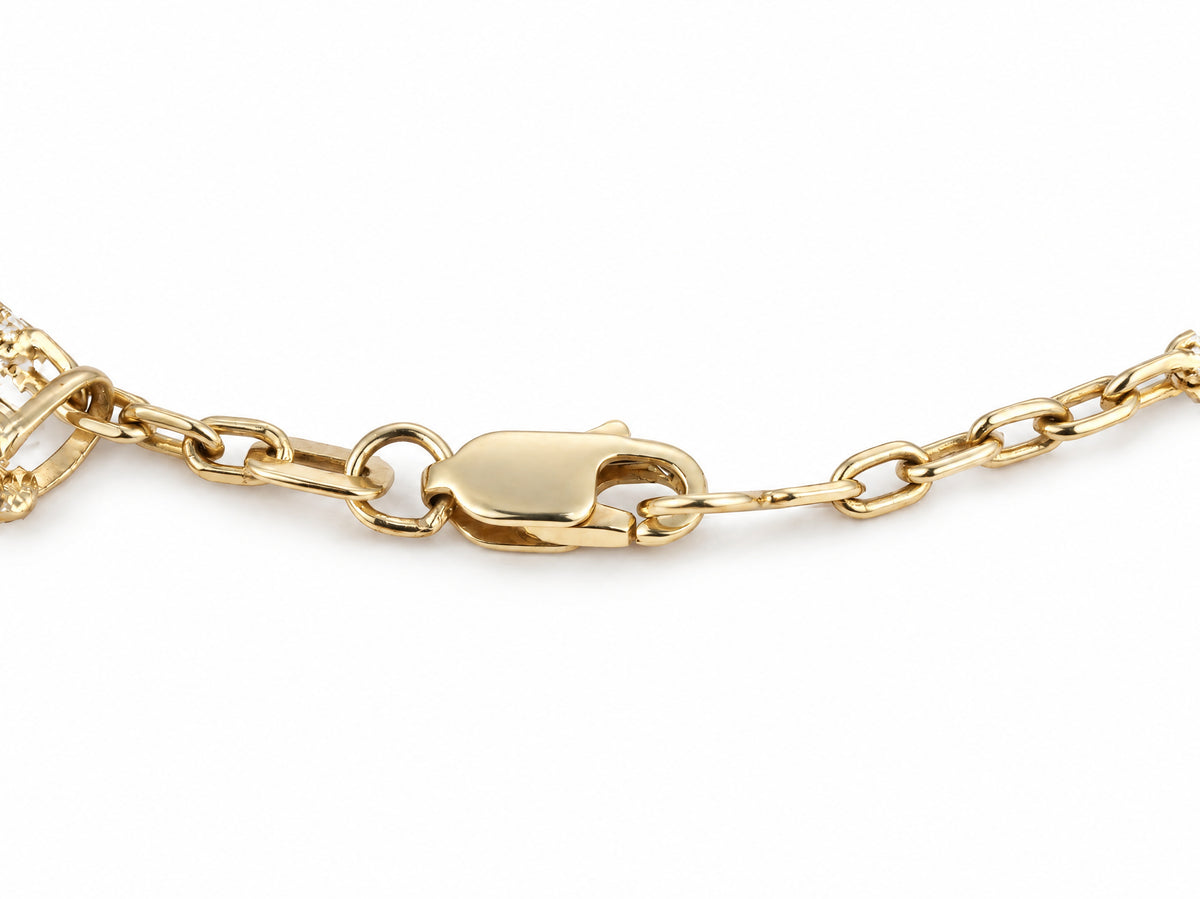 Lobster clasp of the gold charm bracelet with its oval link chain