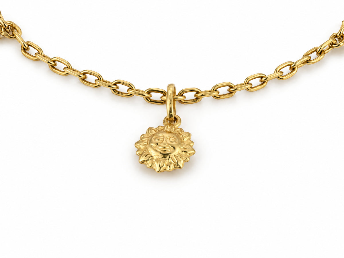 Close-up of the gold sun charm with its face and rays