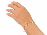 Gold charm bracelet worn on the wrist, second view