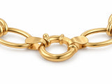 Close-up of the gold bracelet showing two connector rings with a textured finish among polished oval links