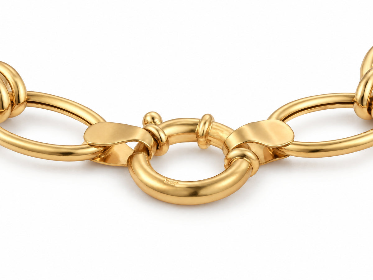 Close-up of the gold bracelet showing two connector rings with a textured finish among polished oval links