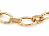 Clasp area of the gold bracelet with a curved bar, a large oval ring and flat plates