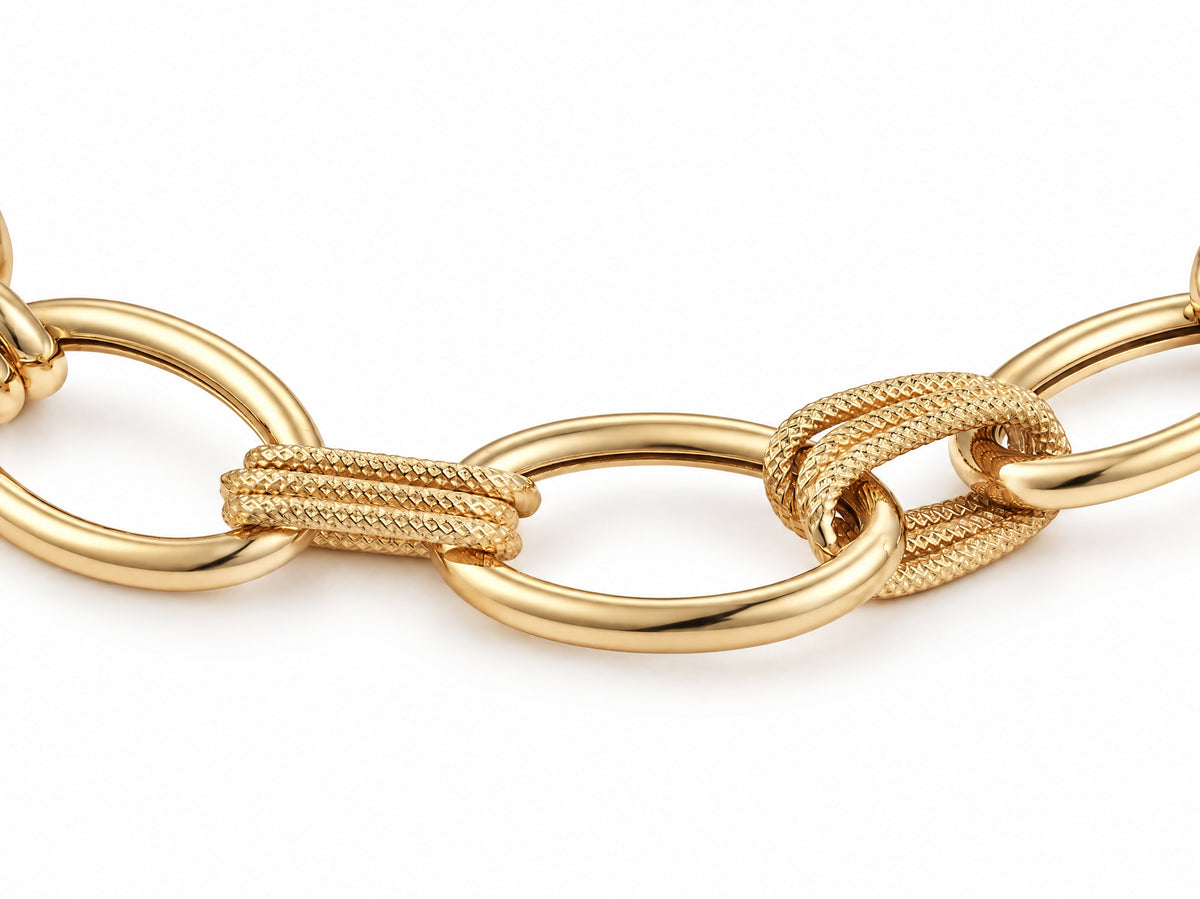 Clasp area of the gold bracelet with a curved bar, a large oval ring and flat plates