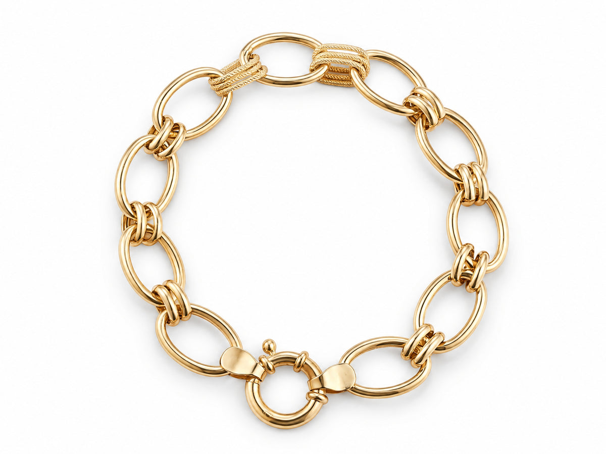 Overhead view of the gold bracelet with large oval links and two textured connectors