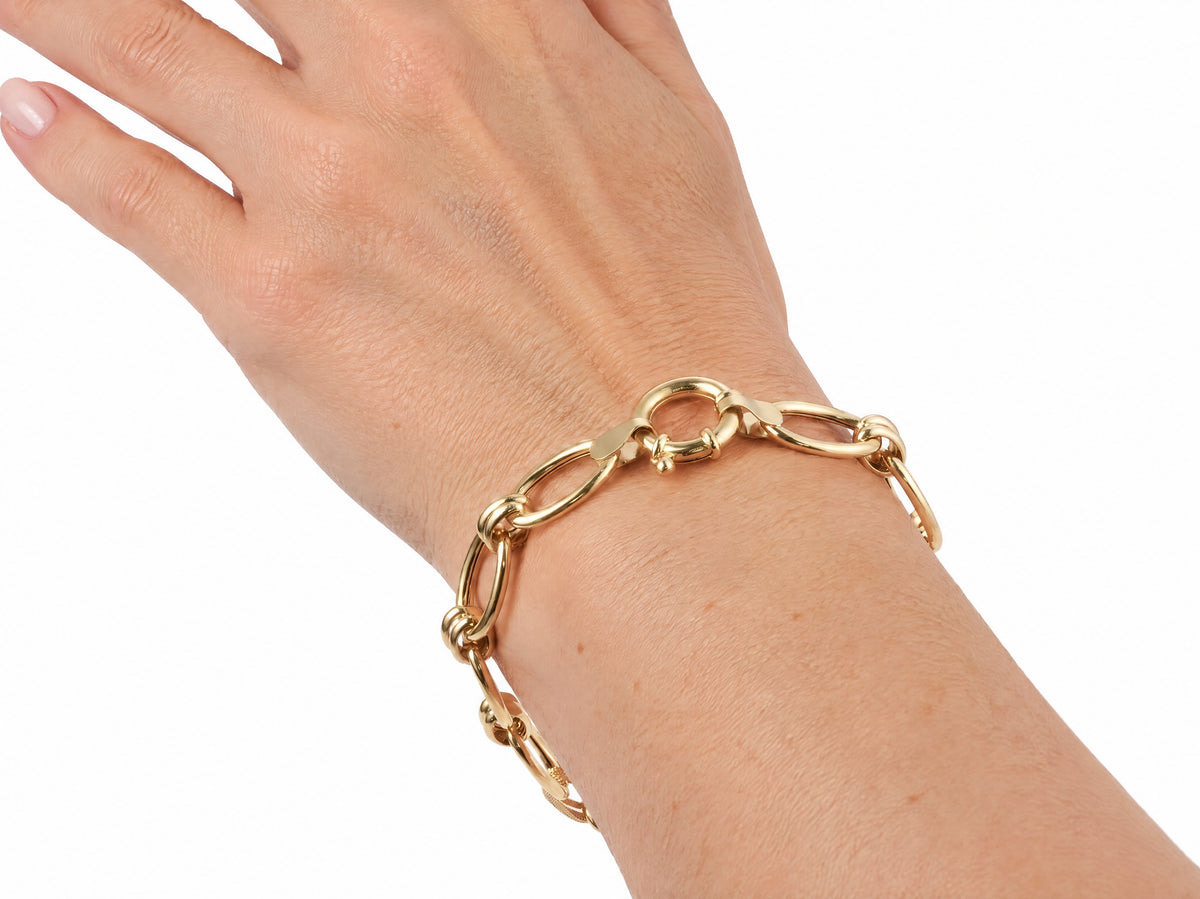 Gold bracelet worn on the wrist with the clasp at the top of the wrist