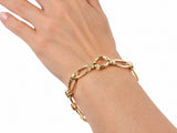 Gold bracelet worn on the wrist with the clasp at the top of the wrist