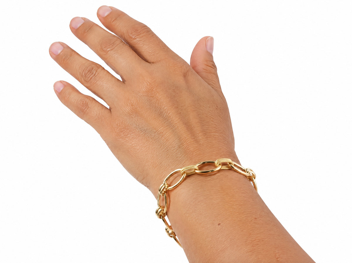 Gold bracelet worn on the wrist with two textured links visible
