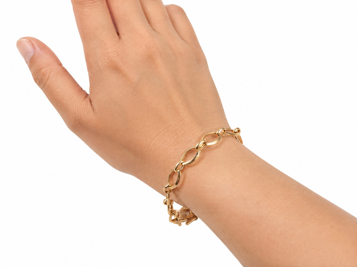 Gold heart lock bracelet worn on the wrist, hand raised palm up