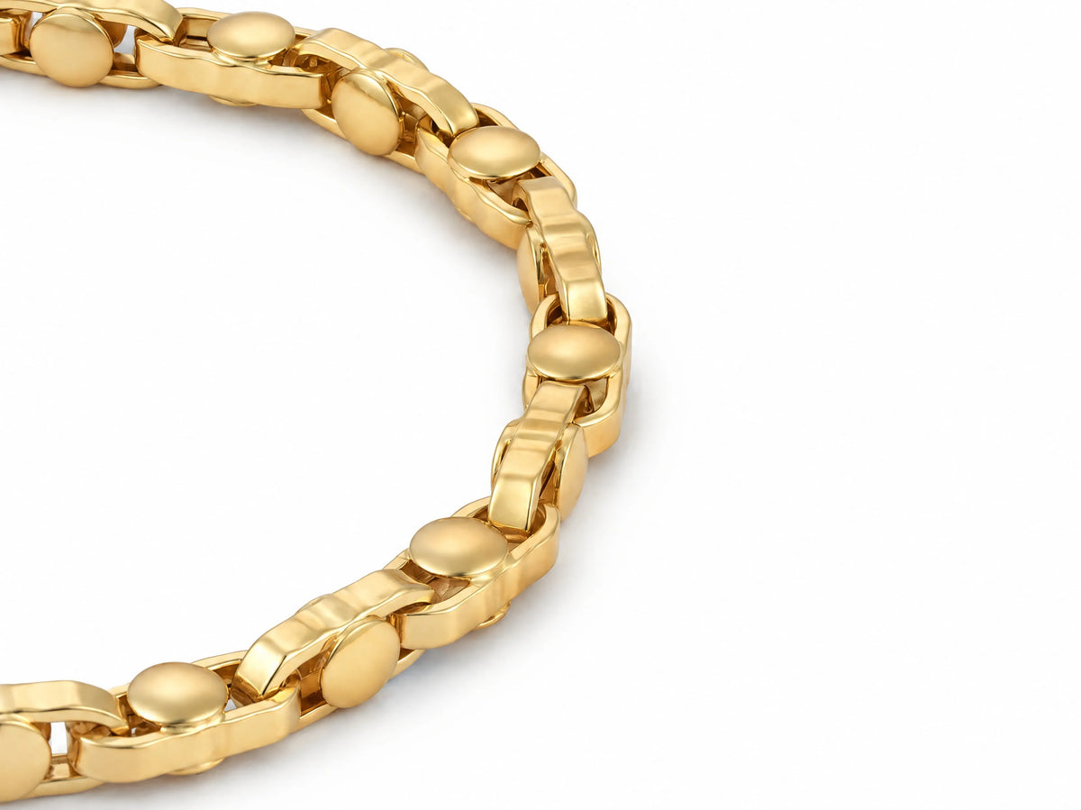 18K yellow gold bracelet shown at an angle with polished rounded links and disc connectors on a white background