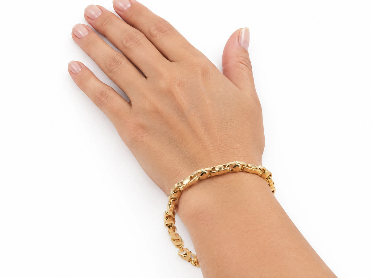 18K yellow gold bracelet worn on the hand, lifestyle shot on a white background