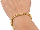 18K yellow gold bracelet with alternating links worn on the wrist