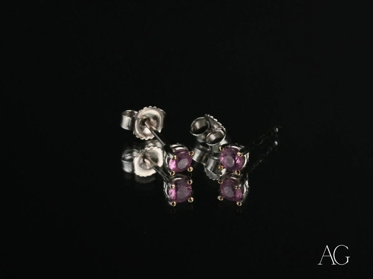 18K gold stud earrings with purple CZ stones, angled side view showing posts and backs
