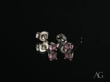 18K gold stud earrings with purple CZ stones, angled side view showing posts and backs
