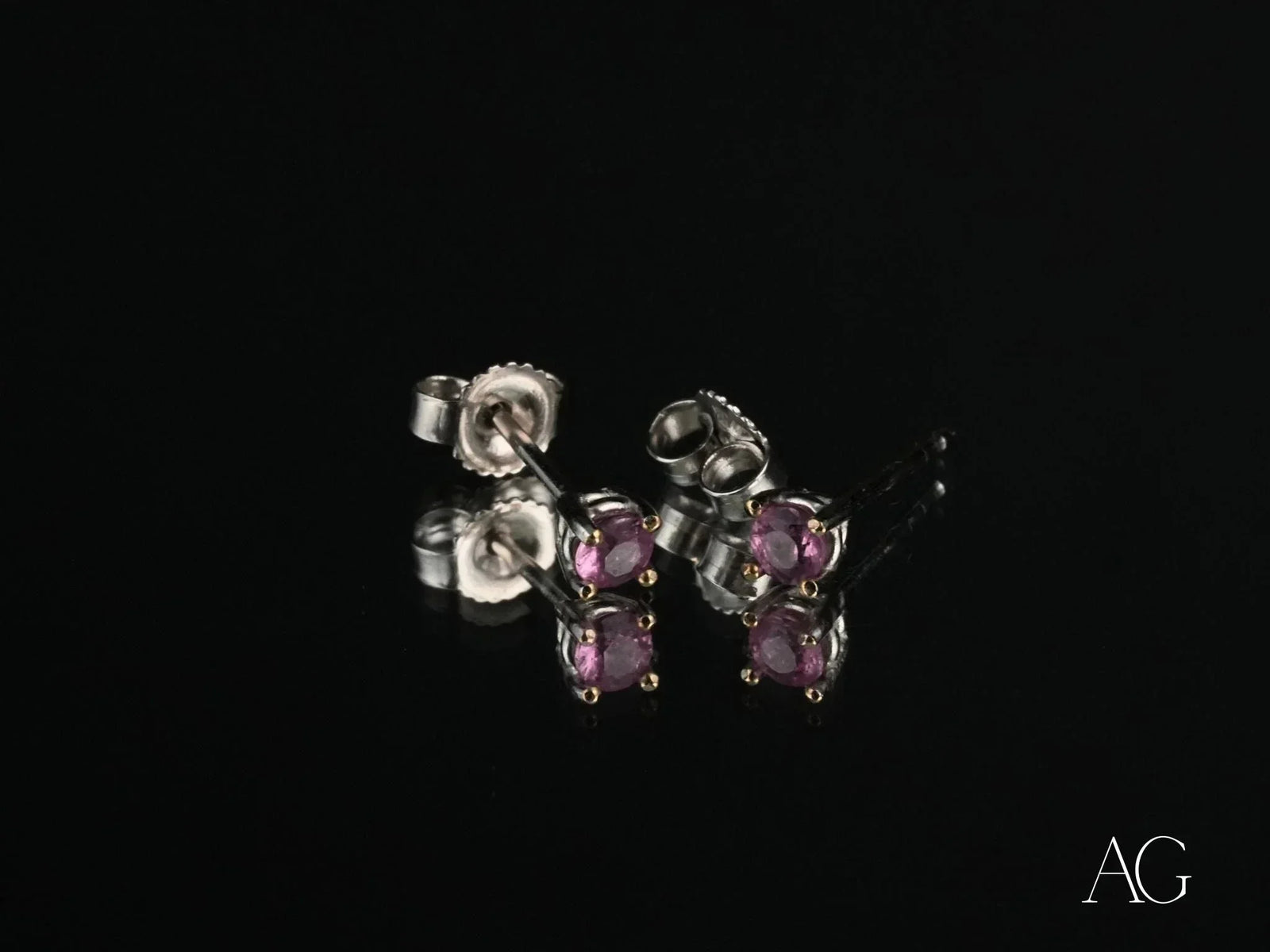 18K gold stud earrings with purple CZ stones, angled side view showing posts and backs