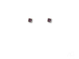 Pair of 18K gold stud earrings with purple CZ stones in four-prong settings, top view