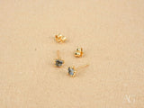 Two 18K gold stud earrings with blue stones and butterfly back closures