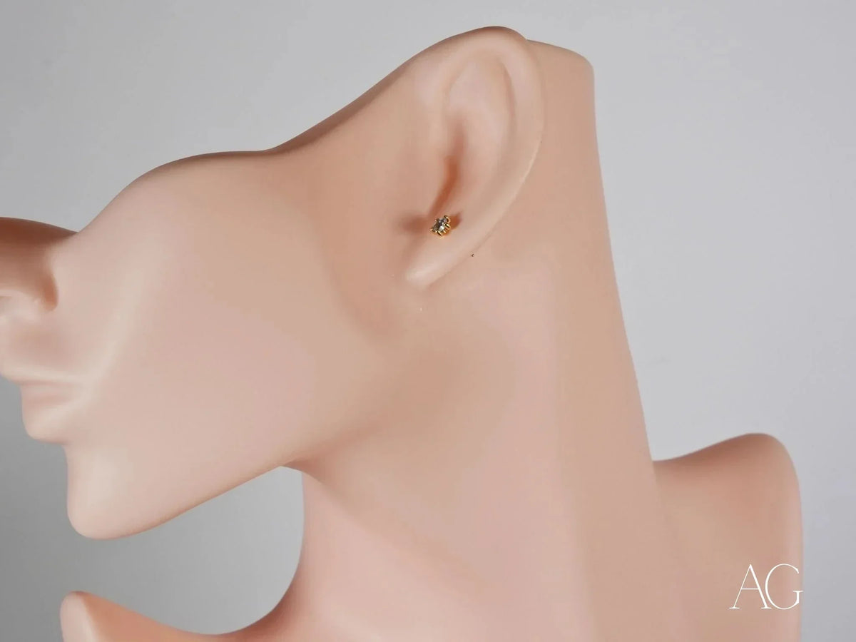 Side view of 18K gold stud earring with blue stone in six-prong setting