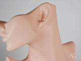 Side view of 18K gold stud earring with blue stone in six-prong setting