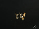 Two 18K gold stud earrings with blue stones on reflective black surface