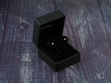 Pair of 18K gold stud earrings with blue stones in six-prong star settings