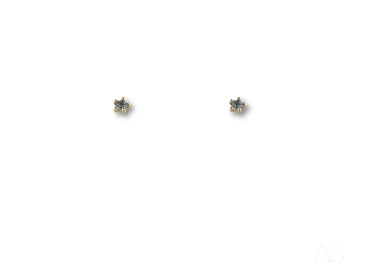 Pair of 18K gold stud earrings with blue stones on white background