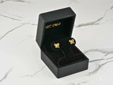 Two 18K gold butterfly stud earrings with cutout wings and cubic zirconia centers, top-down view
