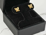 Pair of 18K gold butterfly earrings with openwork wings and central CZ stones, angled close-up view