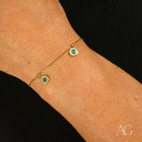 18k gold evil eye bracelet for kids with two dangling blue and white enamel charms, close-up view