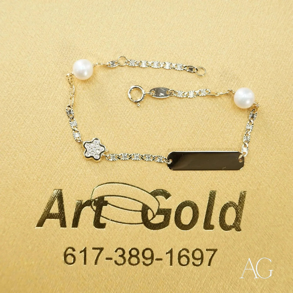 18k gold ID bracelet with pearls, diamond flower, and CZ black charm