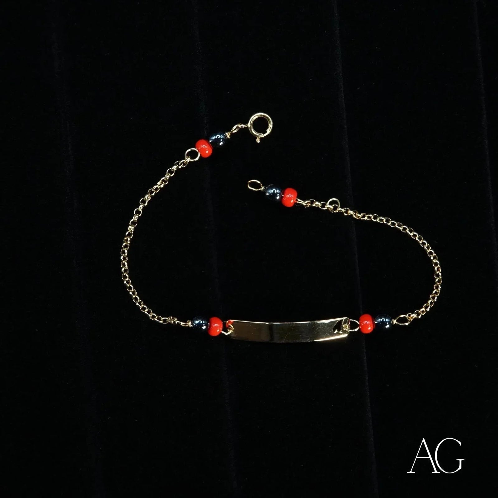 Child’s 18k gold ID bracelet with black coral and heart symbol