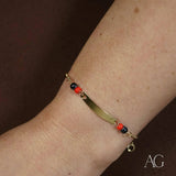 Child’s 18k gold ID bracelet with black coral beads and heart