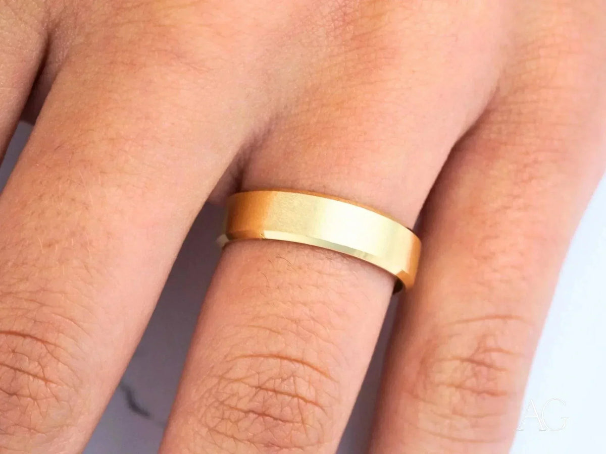 Shiny 18k solid gold wedding band on finger, modern elegance