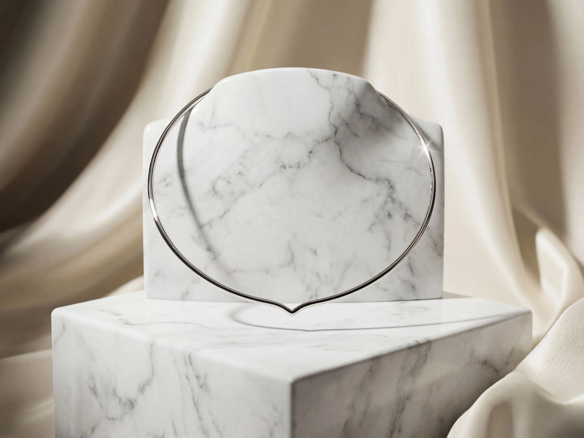 Sleek 18k white gold choker necklace on white marble pedestal