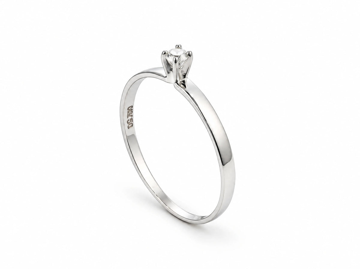 18K white gold diamond solitaire ring standing upright, showing the hallmark inside the band