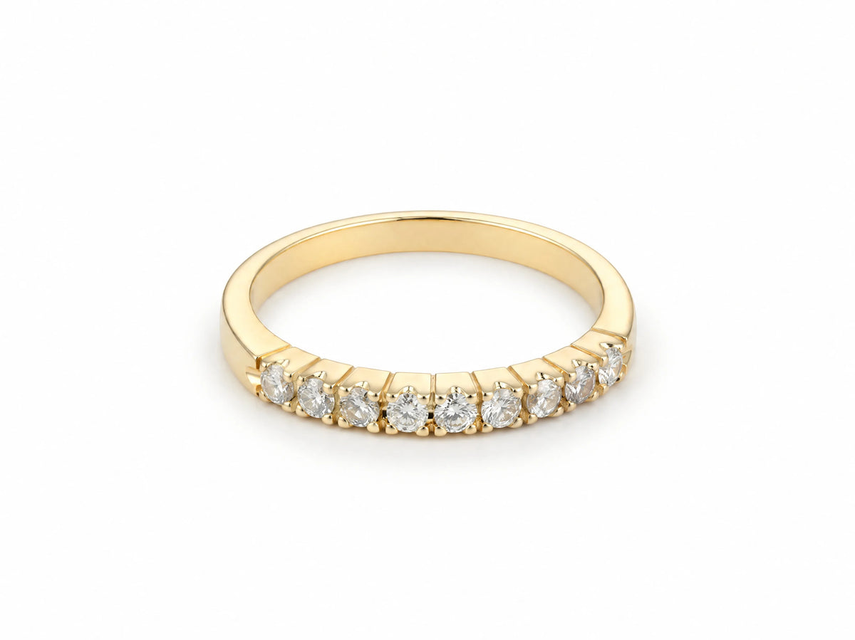 ArtGold 18K yellow gold half eternity band set with nine round diamonds in a single row, front view of the shared-prong setting and polished band