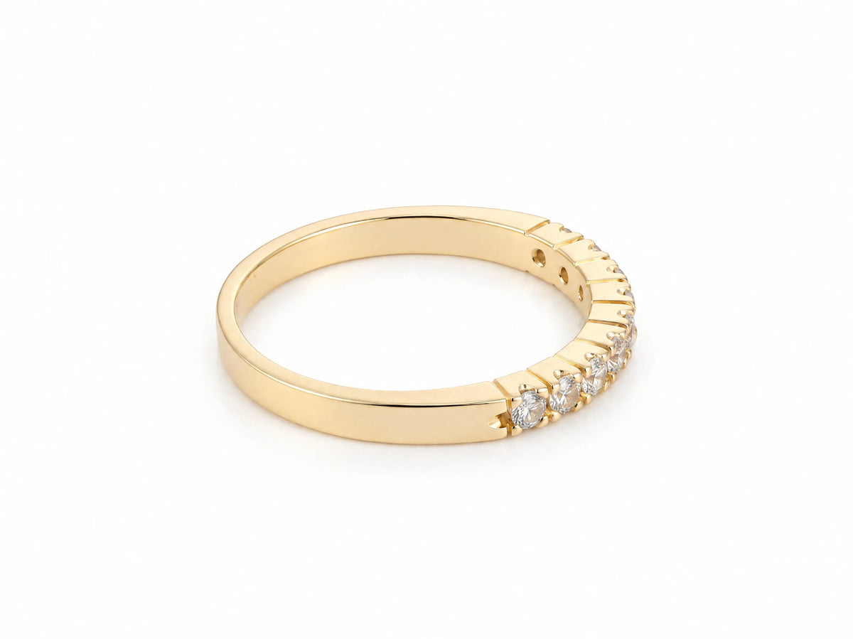 ArtGold 18K yellow gold half eternity diamond band, three-quarter view showing the row of nine round diamonds and the smooth plain back of the band