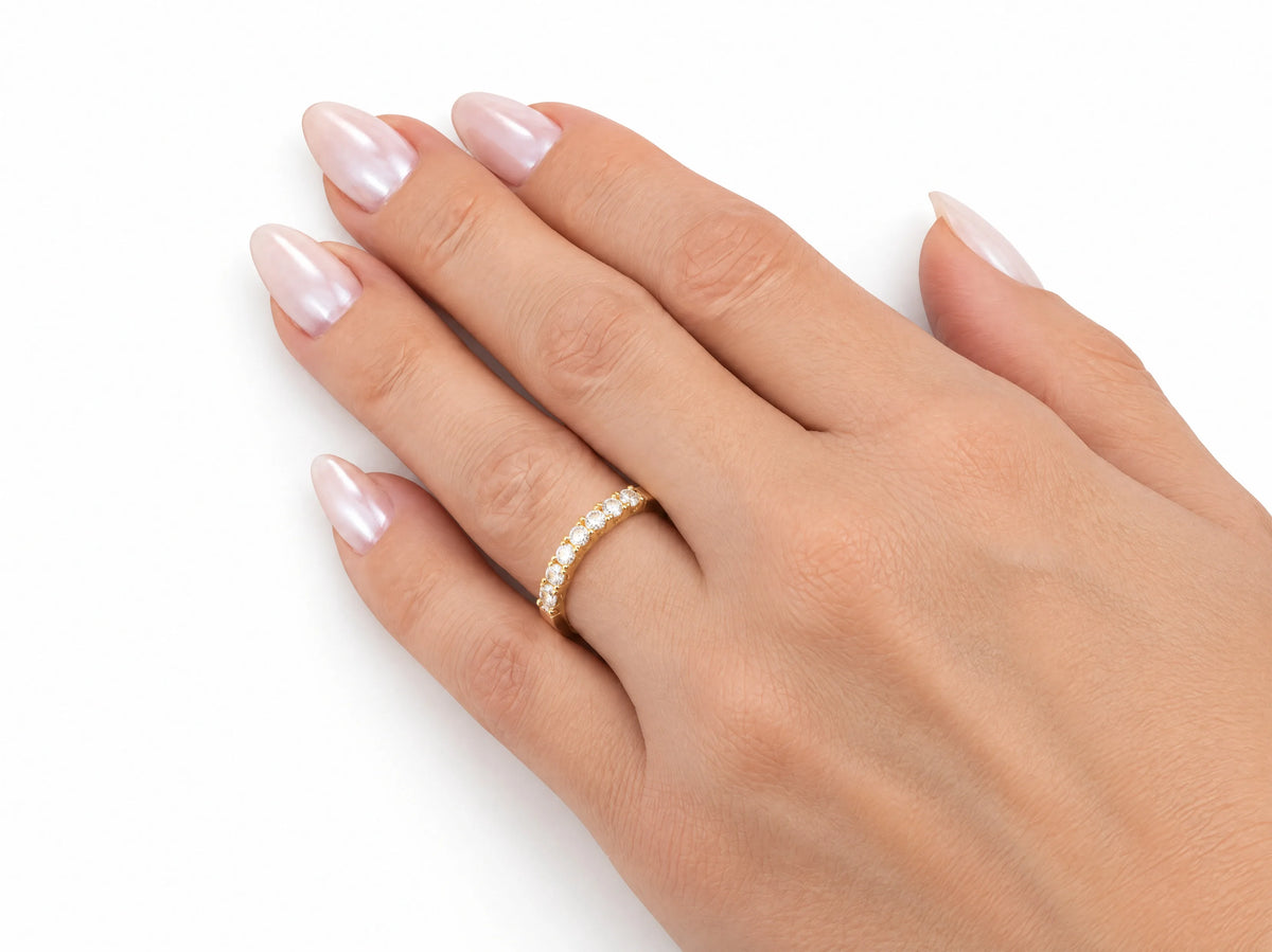ArtGold 18K yellow gold half eternity diamond band worn on the finger, close view of the diamond row