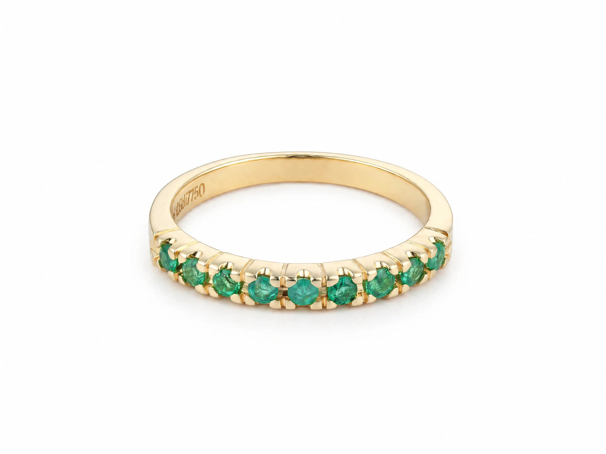 ArtGold 18K yellow gold half eternity band set with nine round green emeralds in a single row, front view of the shared-prong setting and polished band