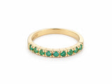 ArtGold 18K yellow gold half eternity band set with nine round green emeralds in a single row, front view of the shared-prong setting and polished band
