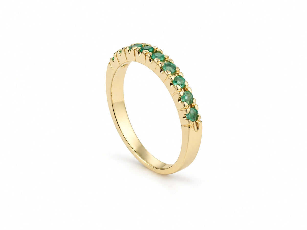 ArtGold 18K yellow gold half eternity emerald band standing upright, showing the polished band and the emerald row