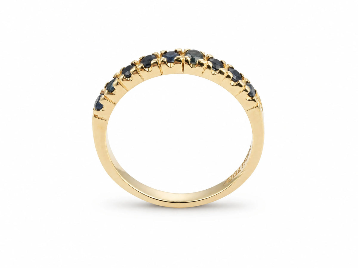 ArtGold 18K yellow gold half eternity sapphire band, upright view of the nine round dark blue sapphires in their shared-prong setting
