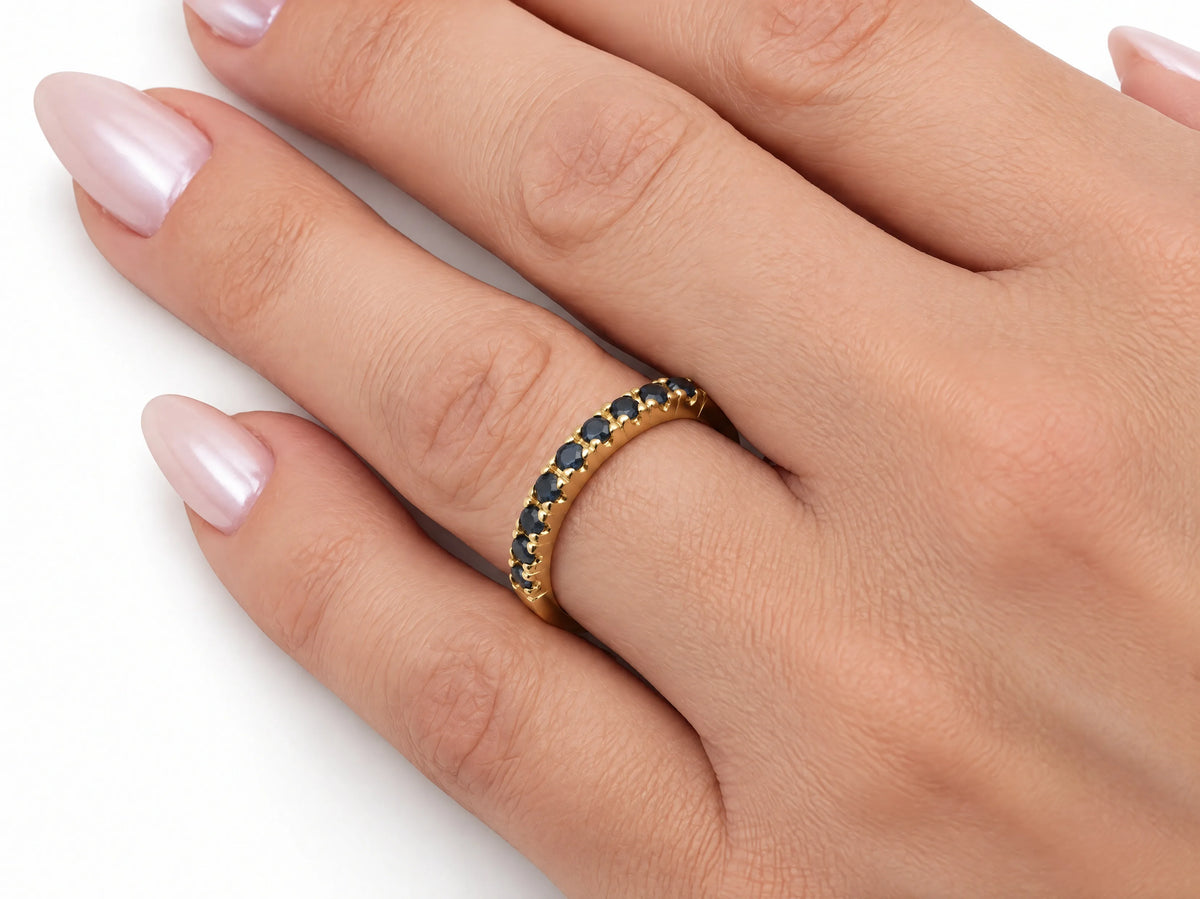 ArtGold 18K yellow gold half eternity sapphire band worn on the finger, close view of the sapphire row