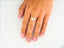 Woman’s hand with French manicure wearing 18k yellow gold heart shape ring with cubic zirconia